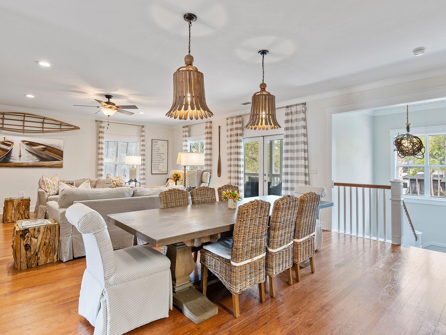 Open second-level dining and living area with hardwood floors and pendant lighting